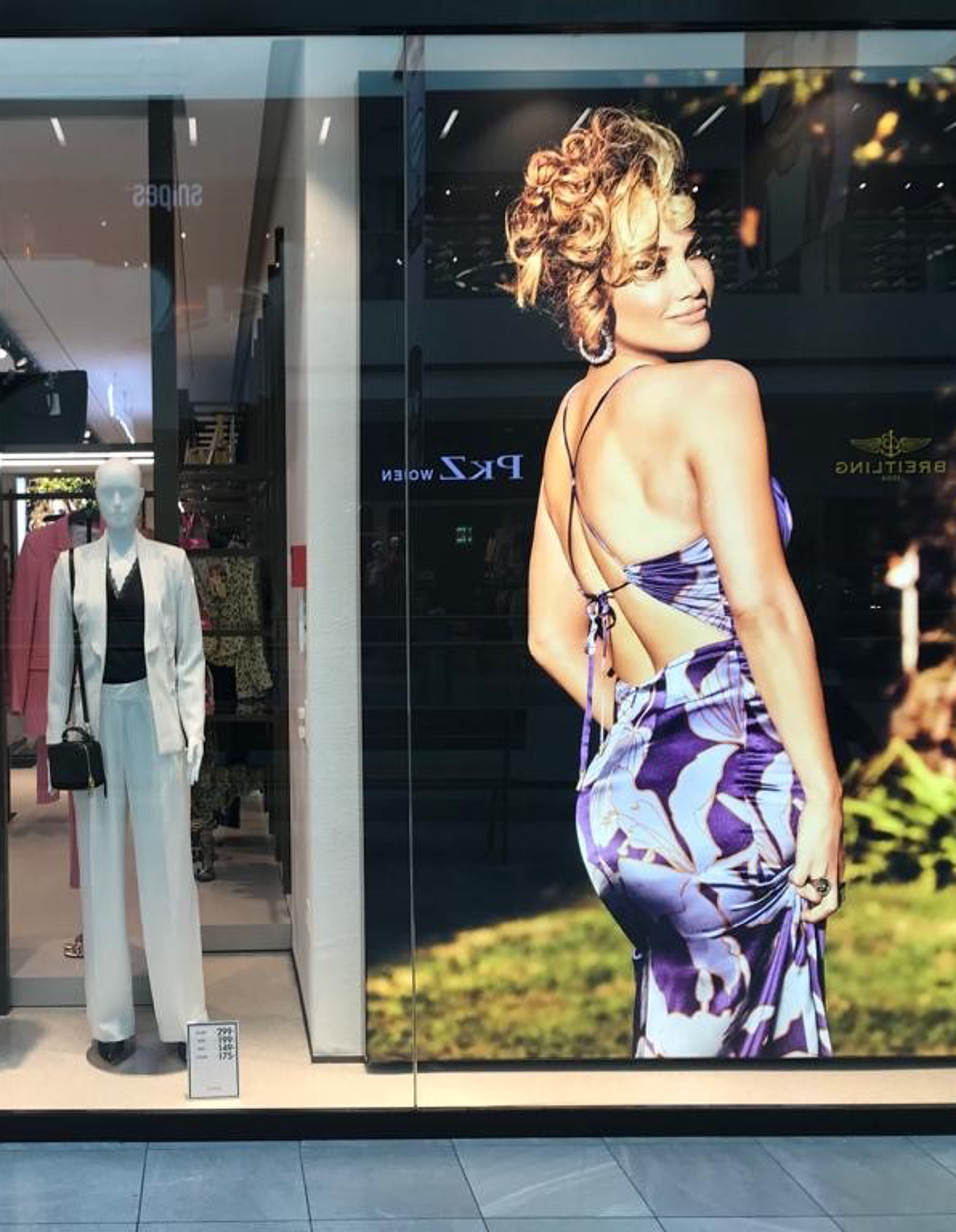 Leuchtkastenbanner im Schaufenster eines Modeladens